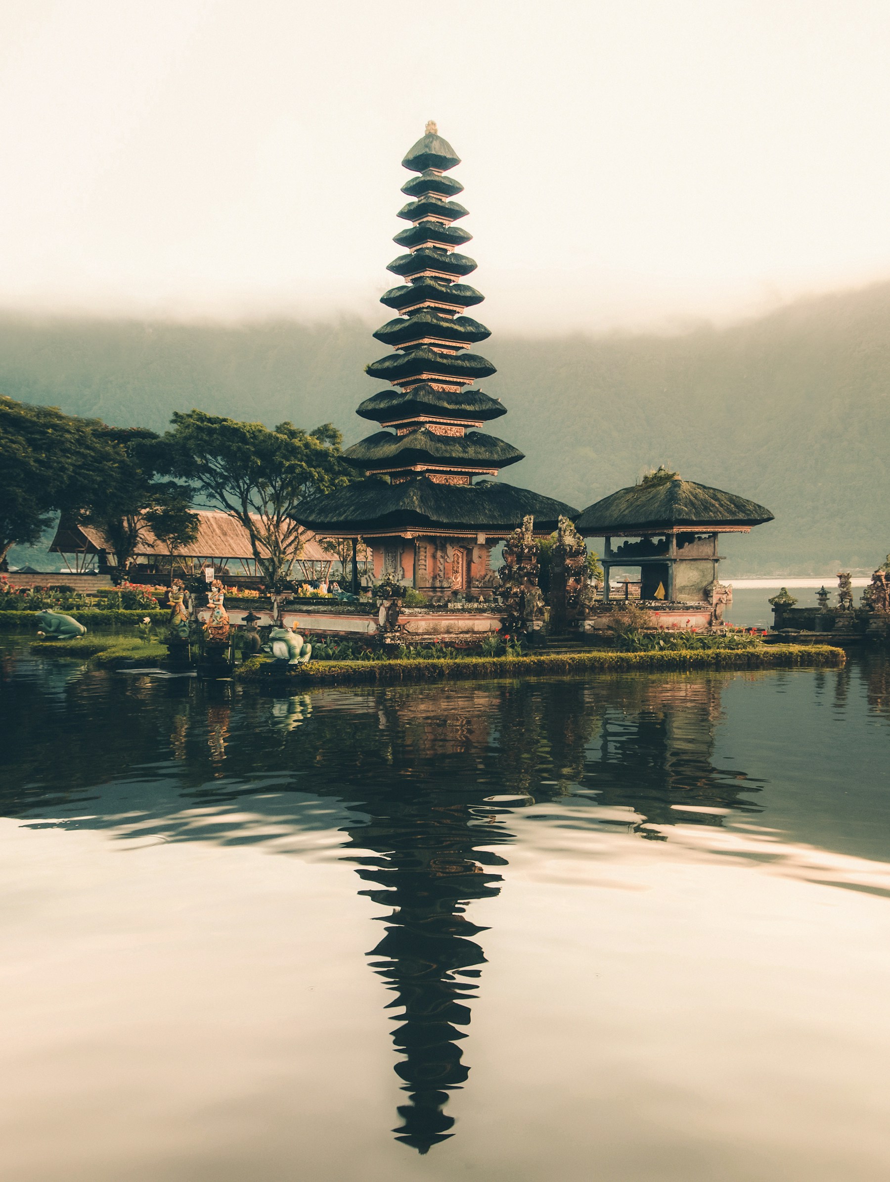 Pura di tepi danau Bali dengan pegunungan dan langit senja